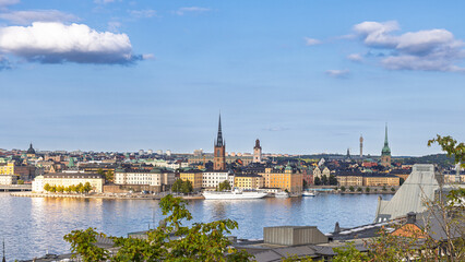 Stockholm, Sweden skyline by the water with historic towers and green hills