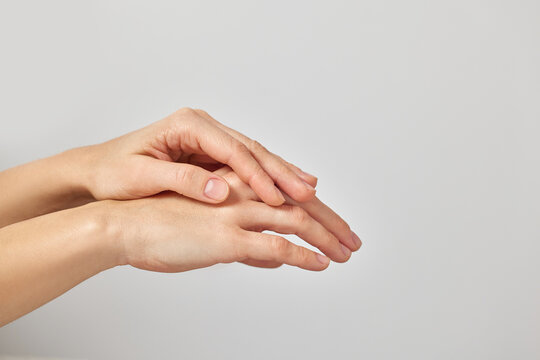 Female hands gently touching, symbolizing skin hydration, care, and wellness on a white background