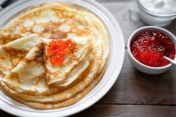 Homemade thin crepes with red caviar