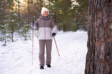Woman in winter park with Nordic walking poles