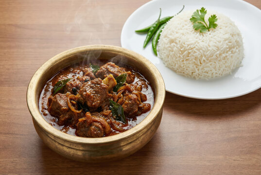 Spicy Indian Mutton Curry with Basmati Rice Served in a Traditional Brass Handi Bowl