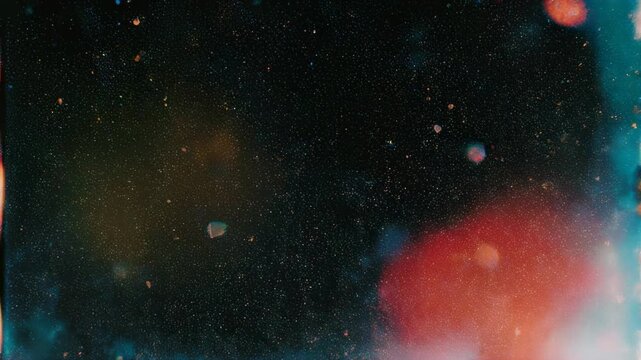 Dark background with many small scattered colorful speckles and soft glowing light blooms