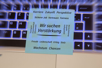 Text WIR SUCHEN VERST&Auml;RKUNG, umgeben von positiven Begriffen wie Karriere, Zukunft, Teamgeist, Vertrauen, Wertsch&auml;tzung, Wachstum und Chancen auf einem auf einem Laptop liegenden Zettel