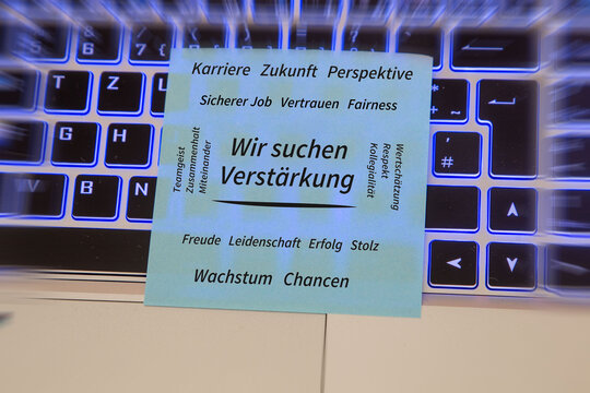 Text WIR SUCHEN VERST&Auml;RKUNG, umgeben von positiven Begriffen wie Karriere, Zukunft, Teamgeist, Vertrauen, Wertsch&auml;tzung, Wachstum und Chancen auf einem auf einem Laptop liegenden Zettel