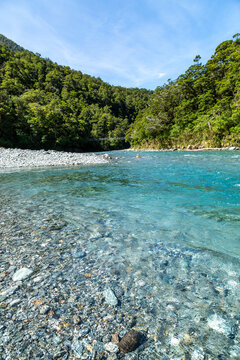 Swing bridge over Blue Pools on the Makarora River surrounded by forest