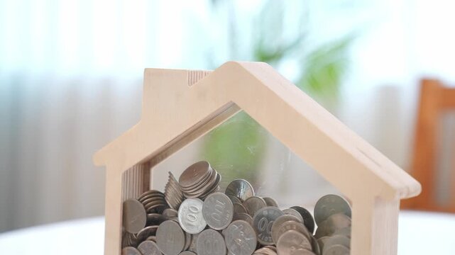 The Journey of Saving: Coin into a House Piggy Bank