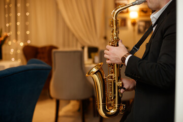 Fototapeta premium Medium closeup of unrecognizable Black jazz musician playing saxophone on stage in local bar