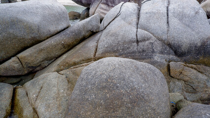 Detailed view of the natural texture and patterns of large granite boulders found along the coastline of Siangau Beach Bangka Island