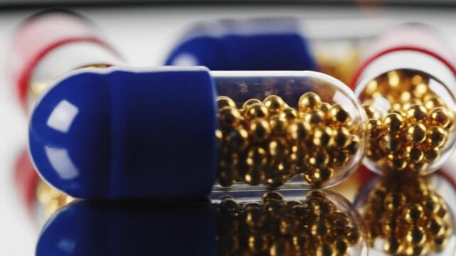 Close up of vitamin k 2 capsules with golden spheres inside healthcare and medical concept