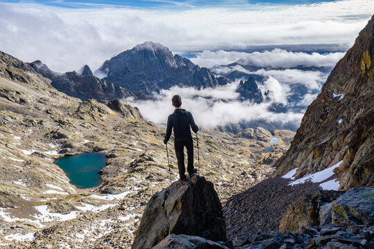 Hiker standing above a sea of clouds at Collet Saint Robert, Mercantour National Park.