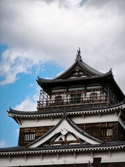Obraz premium Traditional Japanese Castle Architecture Against Cloudy Sky