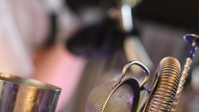 Slow motion refocus shot showing a bartender pouring fresh drinks behind a modern bar during an evening event