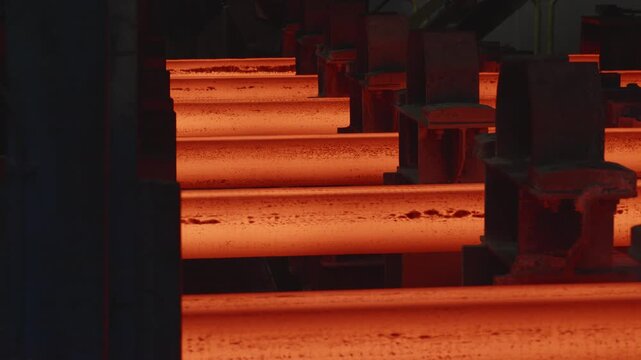 Hot steel billets moving along conveyor system in foundry