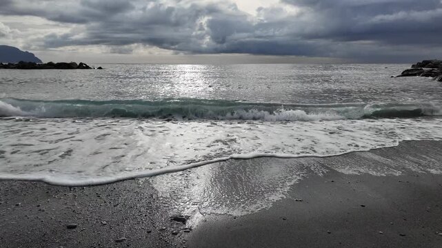 soft waves roll onto sandy beach in winter coastal village bogliasco in slow motion 120fps