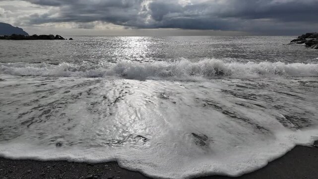 soft waves roll onto sandy beach in winter coastal village bogliasco in slow motion 120fps