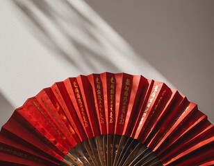 Flat lay of open red Chinese fan on white