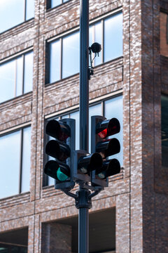 Brick city corner at urban street intersection with traffic signal on pole and lights delivering control for mobility flow and transport safety