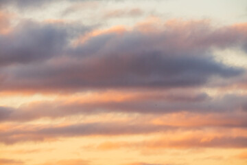 Obraz premium Beautiful sunset sky with soft orange and purple clouds as natural background texture for graphic design or sky replacement projects