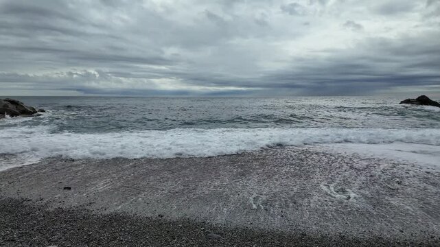 soft waves roll onto sandy beach in winter coastal village bogliasco in slow motion 120fps
