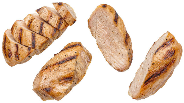 slices and pieces of grilled chicken breast, seasoned with pepper and grill marks, presented against a transparent background, suitable for culinary and advertising use.