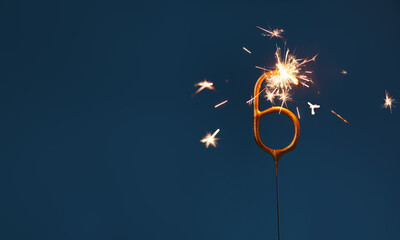 6 years celebration festive background with copy space made with Bengal fire in the form of number Six.