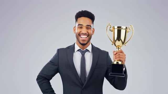 A confident business man in a modern office suit holding a golden trophy