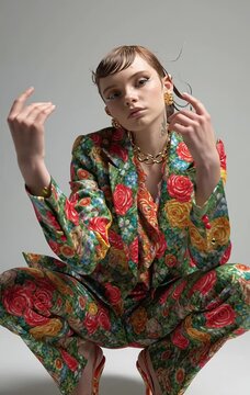 Stylish woman in vibrant floral suit posing confidently