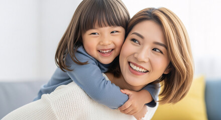 Happy mother giving her young daughter a piggyback ride, both smiling joyfully, celebrating family love and bonding in a bright home setting.
