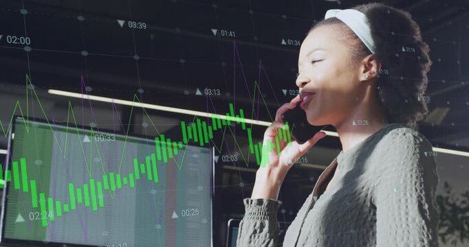 The african american businesswoman is sitting at a table in a modern office, using a smartphone