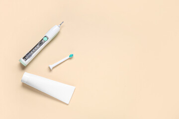 Electric toothbrush with toothpaste on color background.
