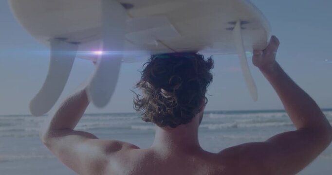 Animation of lights over back view of caucasian surfer on beach