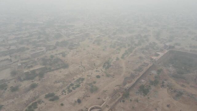 An aerial shot of Derawar Fort's wall and its surrounding area which is a barren desert. 4K Drone Video