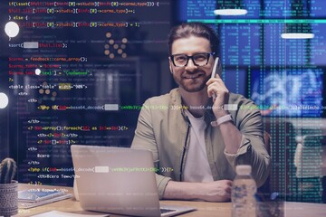 Male programmer talking by mobile phone in office at night