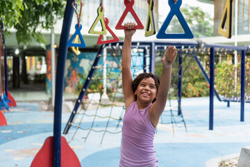 Happy child playing on monkey bars at playground