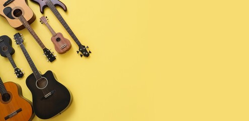 Different guitars on yellow background with space for text, top view