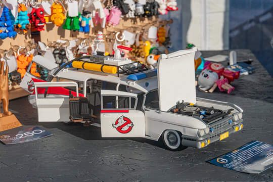 White Ghostbusters toy car with blue graphics and black interior, placed against a blurred backdrop of toy display setting Details on equipment bay are indistinct - Kyiv, Ukraine - September 21, 2025