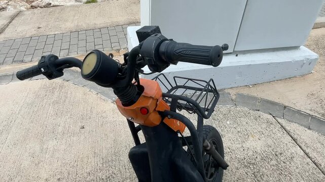 Electric scooter handlebars on concrete background showing control interface and grips