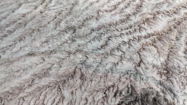 A detailed top-down aerial shot showcasing the intricate crystalline textures and rippled patterns of a massive salt glacier in the Congo, Africa