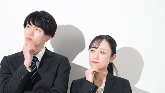 若いビジネスマンの大学生のような男女　新卒採用や就職、就活などどうしようか考える悩むポーズの動画　クローズアップ