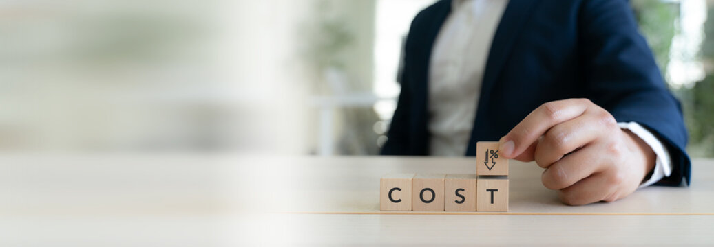 Business Cost Reduction Strategy. Placing a block with a downward percent symbol on wooden COST blocks, representing cost reduction, expense control, savings and financial optimization.
