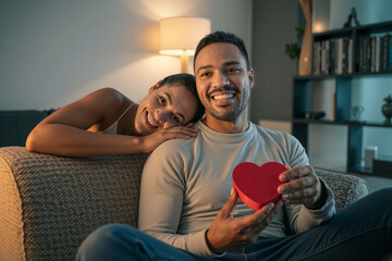Valentine&rsquo;s Day intimate home scene with laughing couple and heart box
