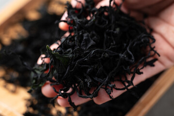 Top view of dried wakame seaweed holding by hand, Healthy Asian food ingredient