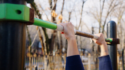 Close up of man hands holding horizontal bar during workout