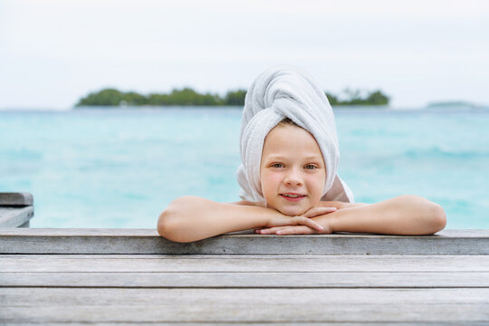 A sweet little girl with a bath towel wrapped around her head. Beauty photo concept.