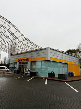 Petrom gas station store with modern glass facade and distinctive yellow stripe design in Moldova.
