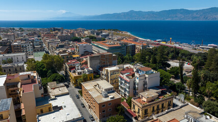 Aerial view of the historic center of Reggio Calabria, Italy. It is the main city in Calabria and overlooks the Mediterranean Sea. On the horizon, silhouette of Sicily and Mount Etna.