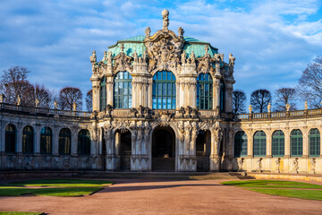 Fototapeta premium People explore the Zwinger palace in Dresden, Germany. The historic site showcases Baroque architecture. Christmas decorations add joy to the visit. Visitors enjoy the gardens and gallery.