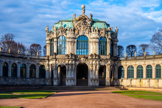 People explore the Zwinger palace in Dresden, Germany. The historic site showcases Baroque architecture. Christmas decorations add joy to the visit. Visitors enjoy the gardens and gallery.