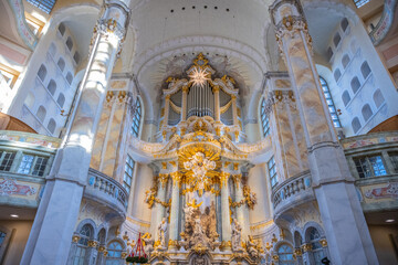 Naklejka premium Visitors explore the interior of Frauenkirche in Dresden, Germany. The dome and ornate details showcase the church's architecture. Light filters through the windows, illuminating the space.