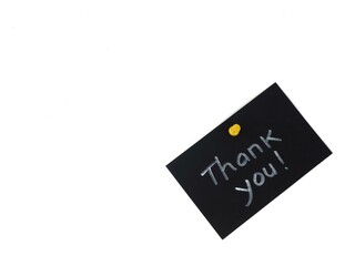 Hand written Thank You message on black paper with push pin on white background. Suitable for appreciation, gratitude, and business communication concept 